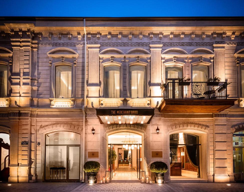 The Merchant Baku illuminated stone facade and entrance at dusk